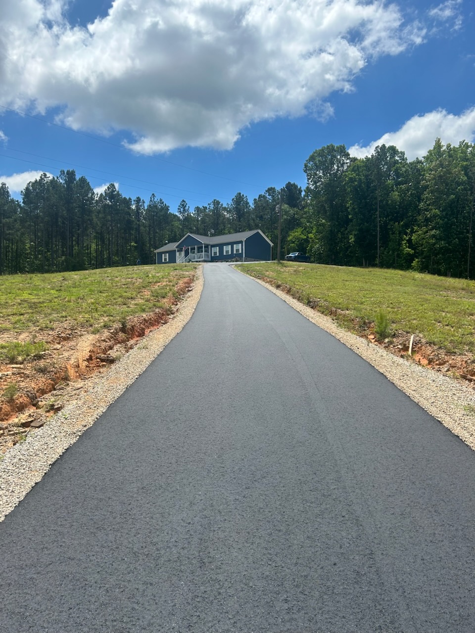 freshly laid asphalt pavement driveway leading to cute blue house in Charlotte NC